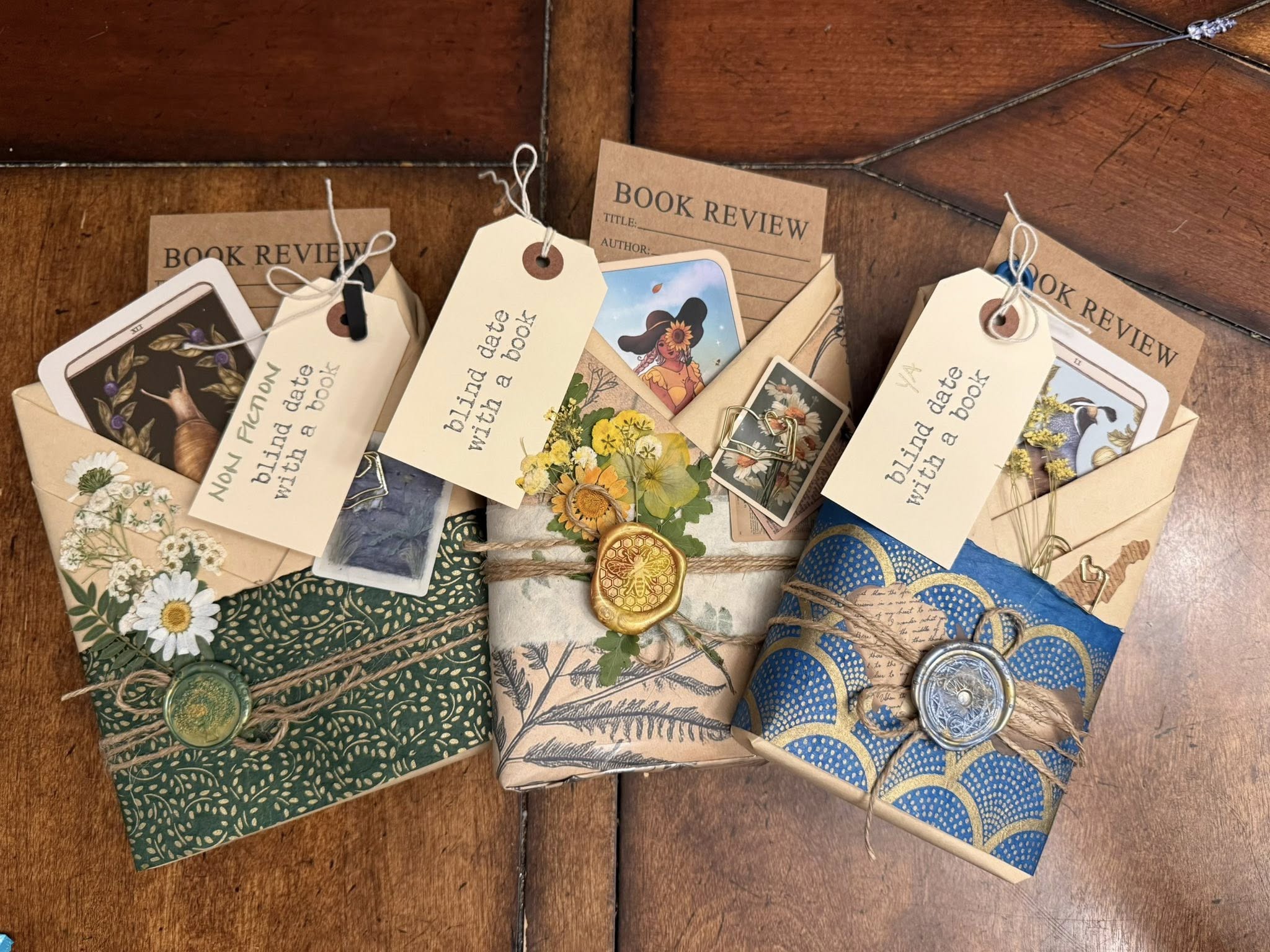Three beautifully hand-wrapped Blind Date with a Book packages with wax seals, pressed flowers, and vintage tags